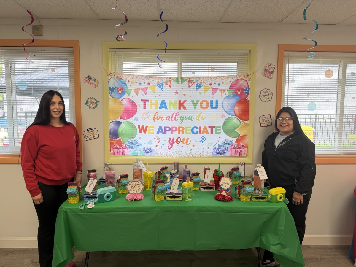 Staff beside the fully loaded gift table on day two